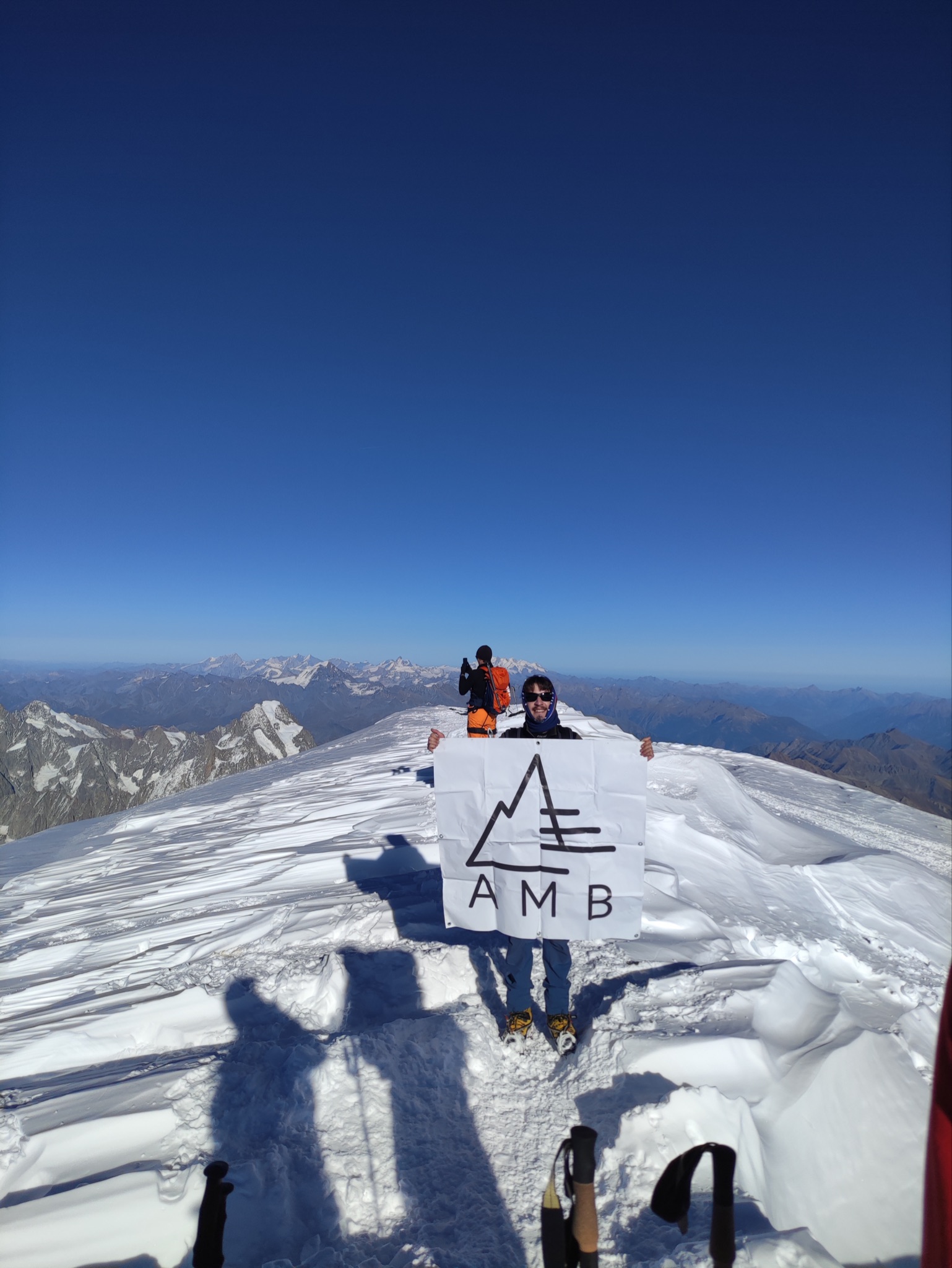 Alpiniste solitaire de l'équipe brandissant la banderole au sommet